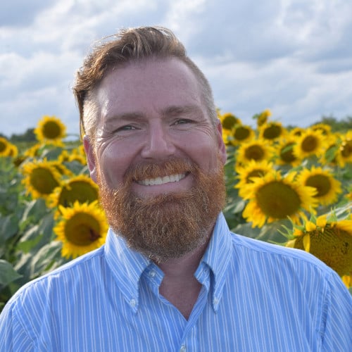 Brian Kabell headshot with sunflowers-2